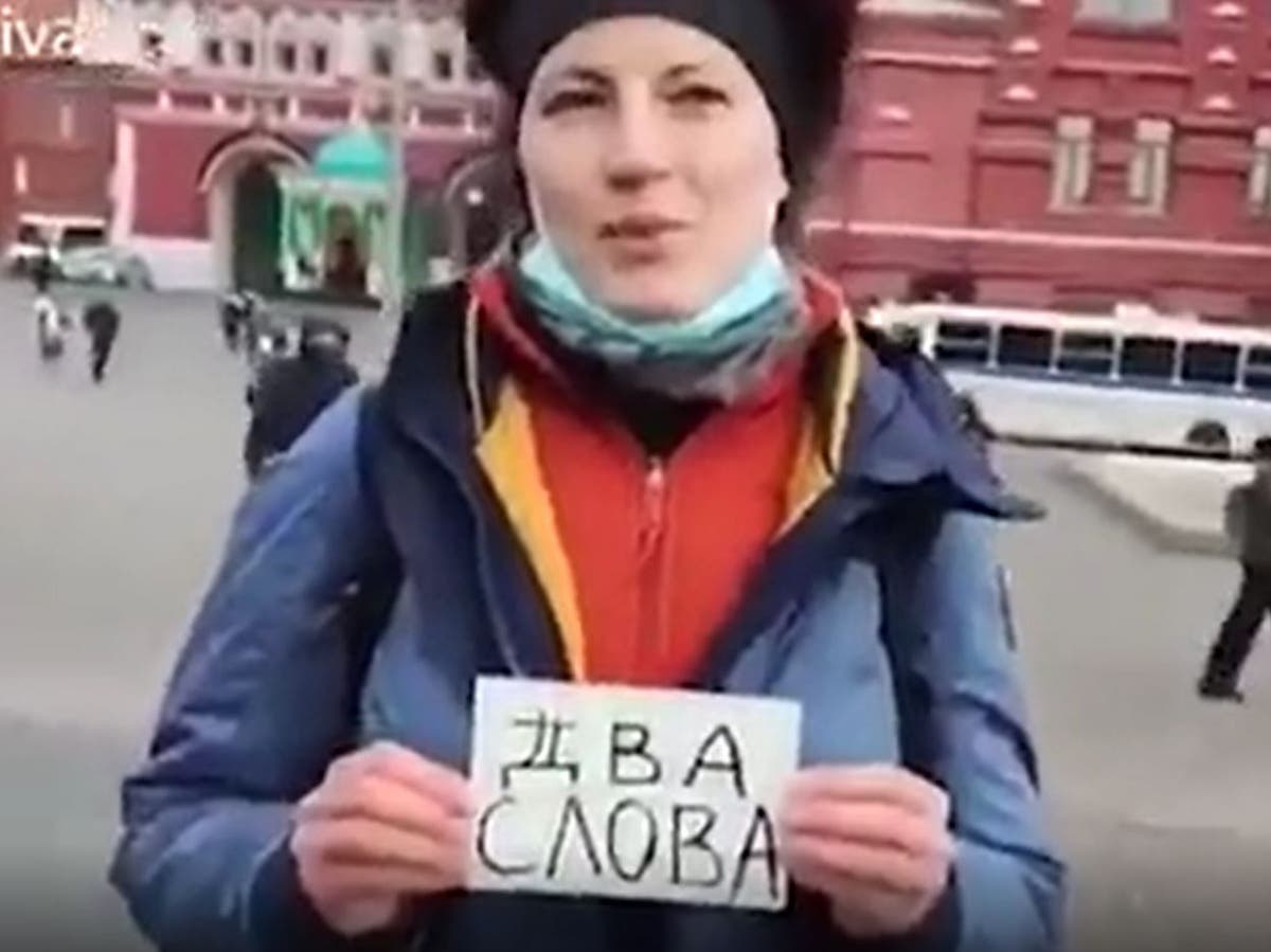 Russian protester holds up sign saying ‘two words’ and is marched off by armed police seconds later