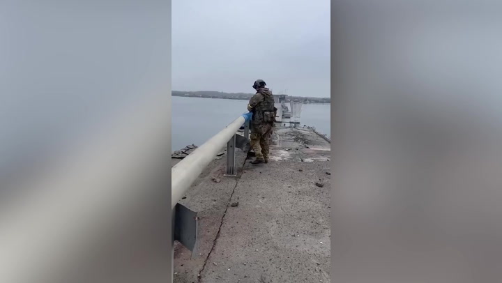 Ukrainian soldiers tie flag to damaged bridge in Kherson region | News