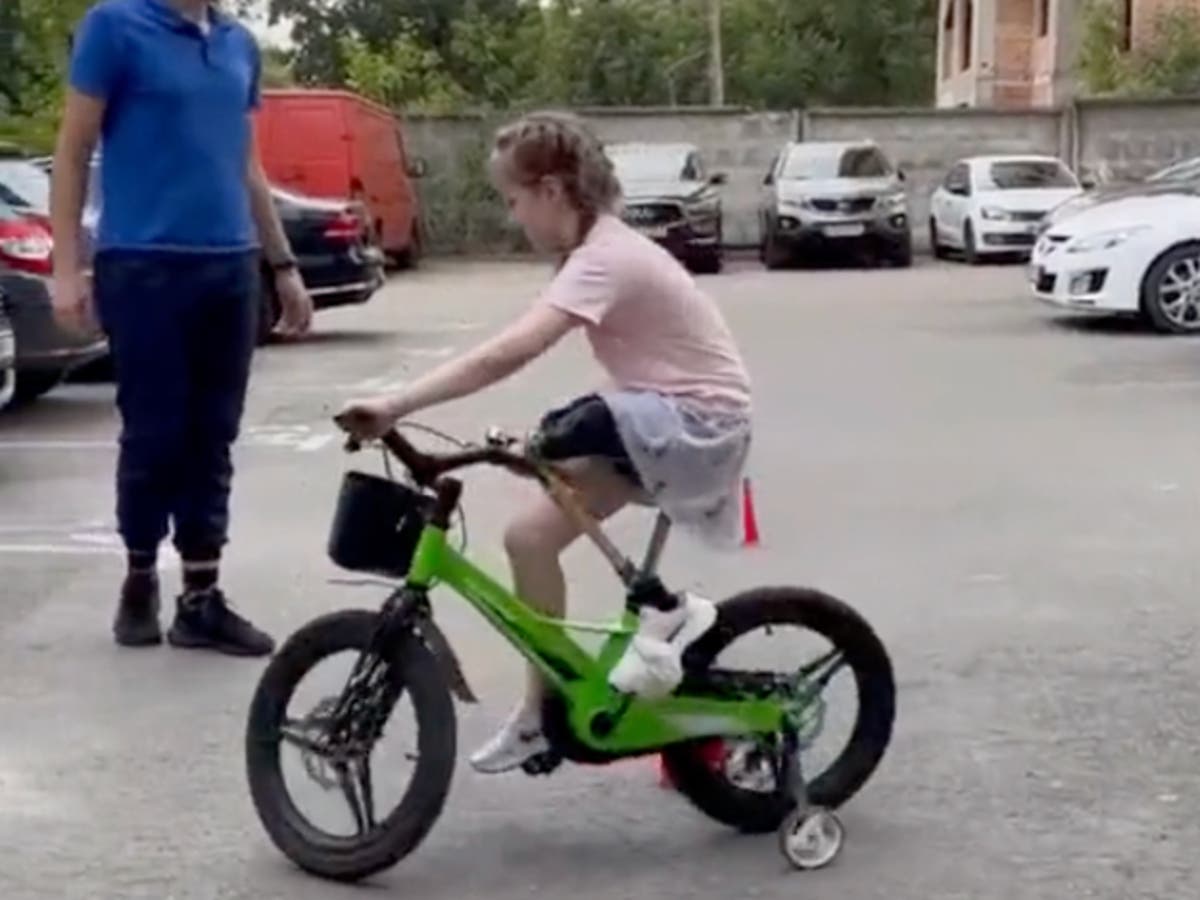Heartwarming moment Russian bomb victim, 6, learns to ride bike again